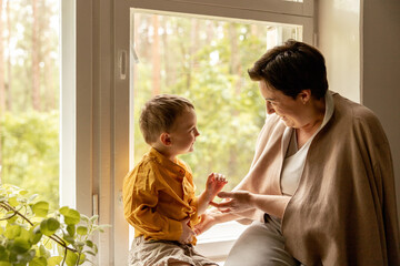 Happy grandmother and grandson enjoy time together. Positive middle age woman spending time with...