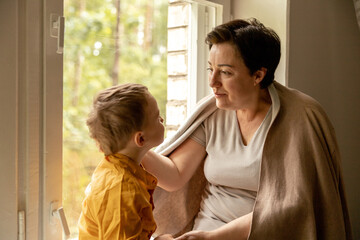Happy grandmother and grandson enjoy time together. Positive middle age woman spending time with...