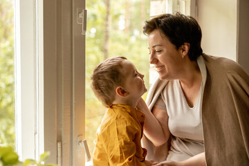 Happy grandmother and grandson enjoy time together. Positive middle age woman spending time with...