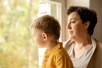 Happy grandmother and grandson enjoy time together. Positive middle age woman spending time with...