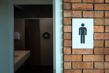 Male or Gentleman icon sign on brick wall in front of the toilet room. Sign and symbol in the building interior object photo.