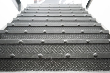 Metallic industrial designed stair step up to the higher floor, close-up and selective focus at...
