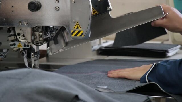 Close-Up Image Of A Sewing Machine Sewing Fabric That A Woman Works With