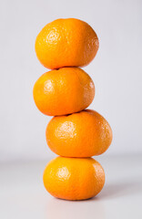tower of four mandarines on white background