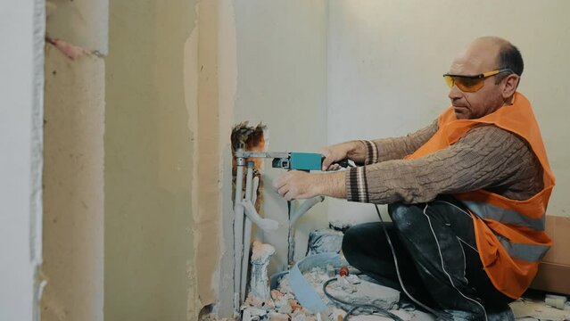 A builder plumber lays water pipes in a bathroom during renovations in a house.