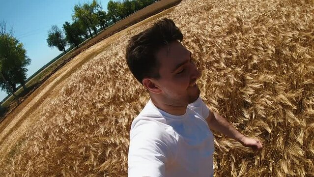 Happy Man Running In Wheat Field Holding Camera In Hand. Pov Gopro Camera Shot. High Quality FullHD Footage