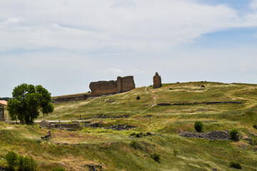 the ruins of the medieval fortress in the mountains. the background is a cloudy sky.