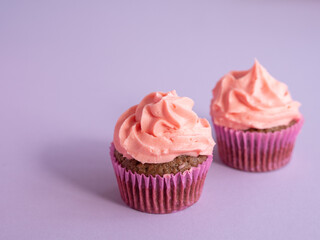 Two cupcakes on a purple background with a side light and a place for text