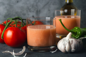 Close up of typical spanish tomato soup (andalusian gazpacho) with fresh tomatoes, green peppers, garlic and olive oil. Glass of delicious gazpacho with copy space.