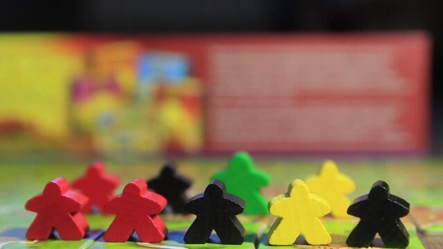 Board game carcasson with tiles and wooden playing pieces close-up.