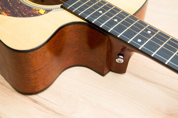 Fototapeta premium A fragment of the body of an acoustic six-string guitar.