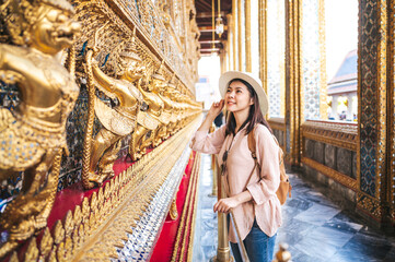 Fototapeta na wymiar Tourist Asian woman enjoy sightseeing while travel in temple of the emerald buddha, Wat Phra Kaew, popular tourist place in Bangkok, Thailand