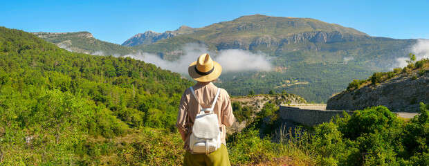 People who admire the beautiful scenery are always a winner. Woman with travel hat and travel bag...