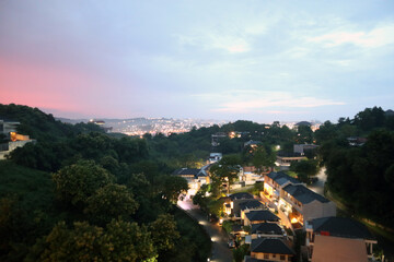 Cityscape buildings view from above with natural green forest trees mountain as part of the scenery