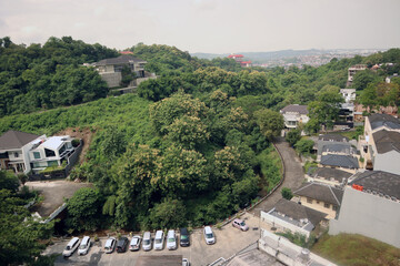 Cityscape buildings view from above with natural green forest trees mountain as part of the scenery
