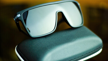 Close up selective focus of Big black stylish wayfarrer sunglasses or shades kept on its case