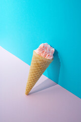 Ice cream pink cone on a pink and blue background. Minimal summer concept.