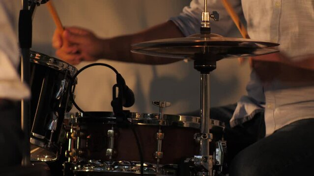 The drummer beats the drums. Close-up of drums rocking in concert. A cinematographic picture. Soft focus on objects.
