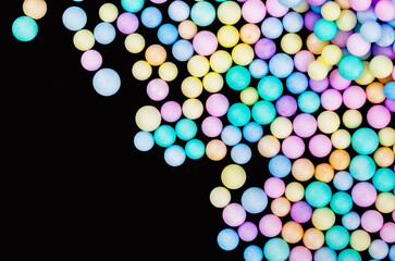 Foam beads of various colors brightly colored on black color background