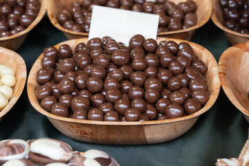 chocolate candies, nuts in chocolate glaze close-up in a plate