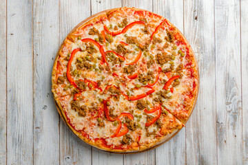 Mexican pizza with meat and red pepper with cheese and tomato sauce top view on white wooden table