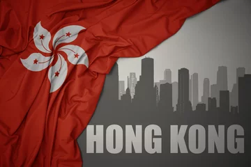 Foto op Plexiglas abstract silhouette of the city with text Hong Kong near waving national flag of hong kong on a gray background.3D illustration © luzitanija