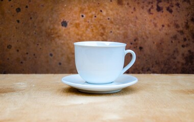 Cup of coffee with coffee beans on a wooden table. White cup with espresso coffee. Background for a coffee shop. Arabica.