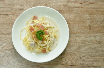 steamed spaghetti white cabonara cream sauce topping slice ham pork on plate