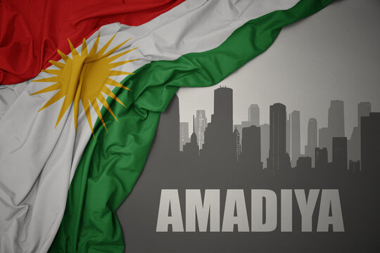 abstract silhouette of the city with text Amadiya near waving national flag of kurdistan on a gray background.3D illustration