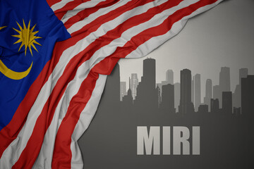 abstract silhouette of the city with text Miri near waving national flag of malaysia on a gray background.3D illustration