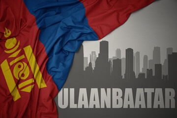 abstract silhouette of the city with text ulaanbaatar near waving national flag of mongolia on a gray background.3D illustration