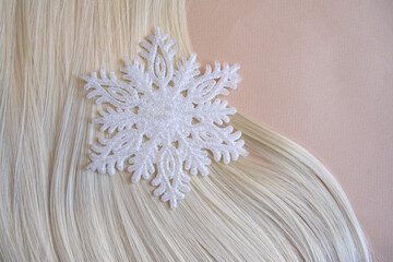 female blonde hair and snowflake, cold weather hair care concept. Top view, copy space
