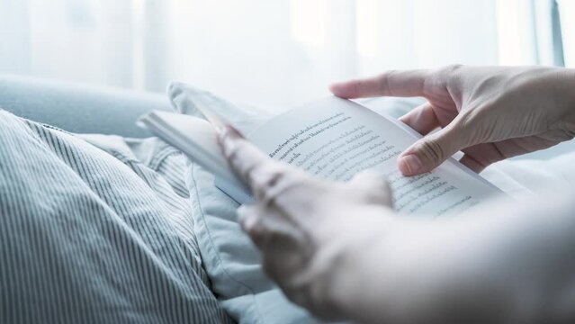 Young woman reading book in cozy living room, turning page, learning, studying, education, read books, stay home concept.