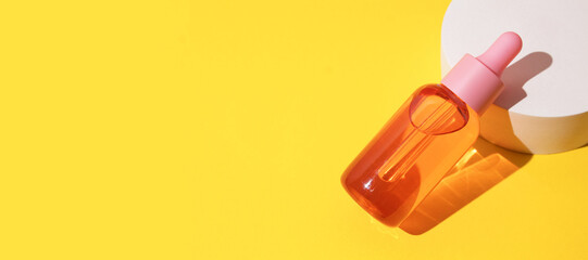 Cosmetic bottle with serum or oil on podium. Sun protection lotion, sunscreen. Summer skin care concept with spf. Horizontal long banner for web design with copy space