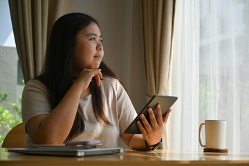 Portrait with plus-size overweight woman using digital tablet at home, Domestic life concept.