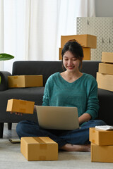 Young asian woman entrepreneur work from home with online on notebook, Online shopping, Logistic and delivery, Online selling, Internet marketing, E-commerce concept.