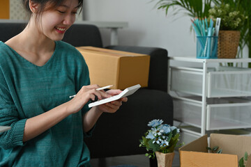 Small business owner working with calculator, The seller prepares the delivery box for the customer with postal parcel. Selling online and delivery.