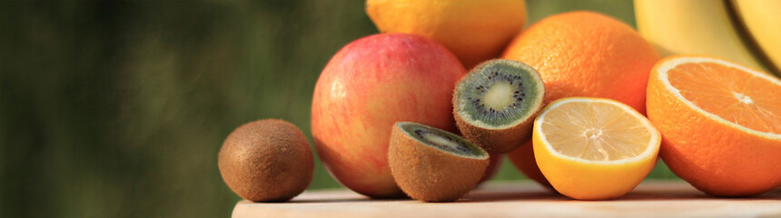 Website banner with kiwi, oranges, lemon, apple and bananas. Set of ripe fruits with selective focus