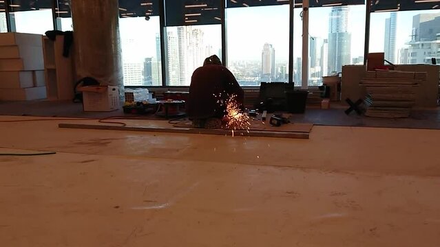Man saws metal with an angle grinder