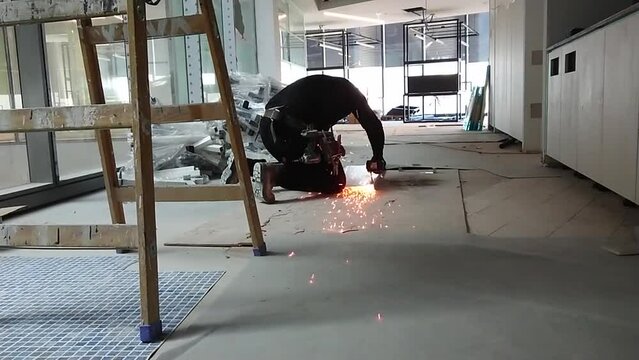 Man cuts metal with a angle grinding machine