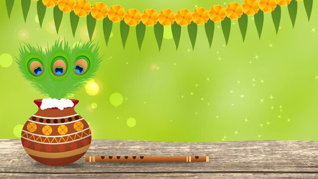 Pot, peacock feather and flute on wooden desk isolated on green blur background. Celebrating god Krishna's birthday.