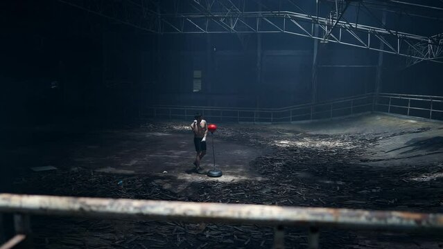 4K Strong Asian sportsman athlete do combat sport training workout boxing exercise with punching bag in abandoned building. Active man boxer practicing fighting exercise kickboxing in dark old gym