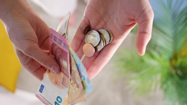 Hands hold different euro banknotes and euro coins. State aid in times of crisis to compensate for inflation. Salary increase and basic social security. Inflation, purchasing power and social crisis.