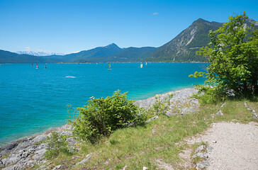 Walchensee lake shore, mountain view and windsurfer at the water, bavarian landscape