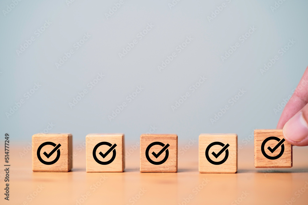 Poster Hand putting and array correct sign which print screen on wooden cube block for approve document and project concept.