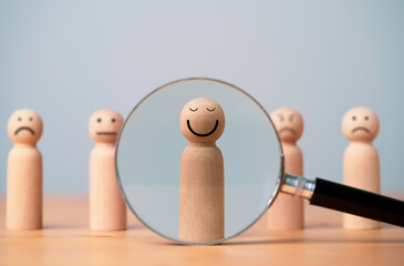 Smiley face on wooden figure with inside magnifier glass for focus of satisfy and happiness of...