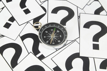 Direction search and navigation concept. Compass on many question marks background.
