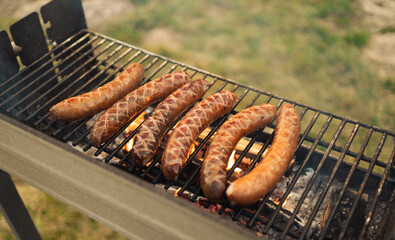 Grilling sausages on barbecue grill. Selective focus. 