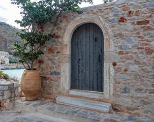 Traditional stonewall building at Mani Laconia, Peloponnese Greece. Ceramic pot with green plant.