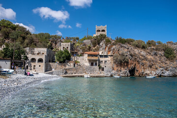 Greece. Rocky beach, moored boat in calm sea, Mani Laconia, Peloponnese crystal clear water.